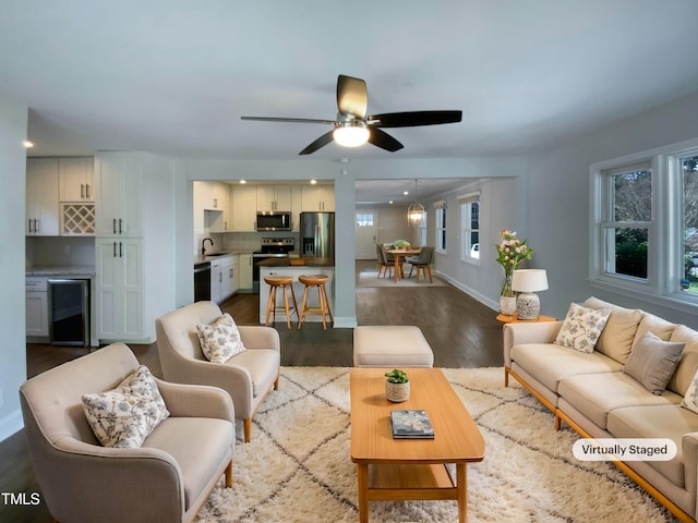 living room featuring ceiling fan, plenty of natural light, wine cooler, and dark hardwood / wood-style flooring