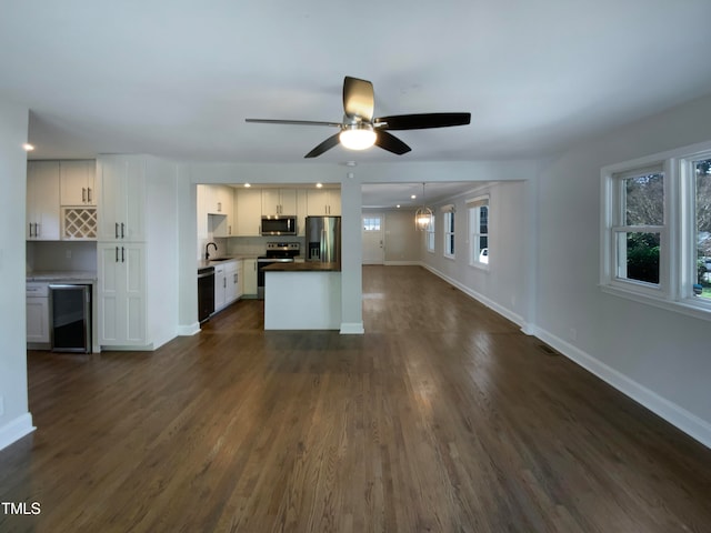 kitchen featuring stainless steel appliances, a wealth of natural light, white cabinetry, and tasteful backsplash