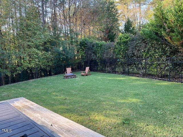 view of yard featuring a wooden deck and a fire pit