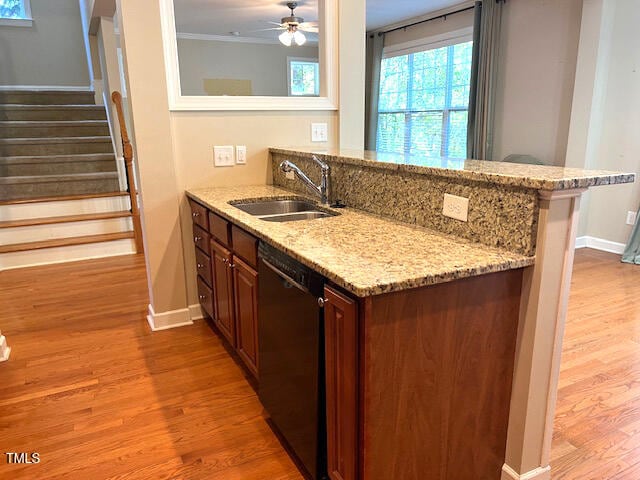 kitchen featuring black dishwasher, light stone countertops, sink, kitchen peninsula, and light hardwood / wood-style flooring