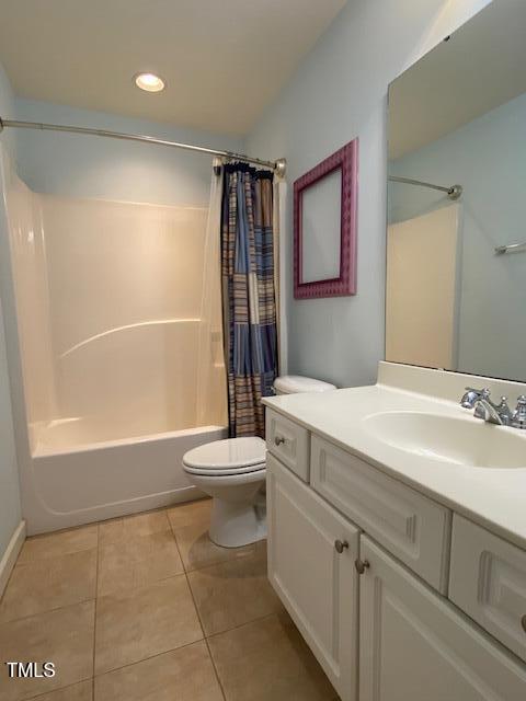 full bathroom featuring tile patterned flooring, vanity, shower / bath combo with shower curtain, and toilet