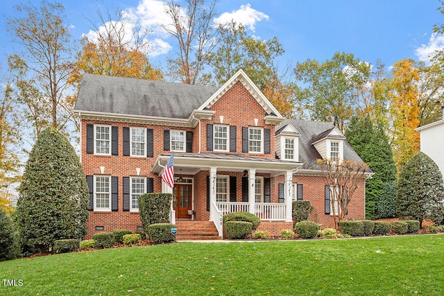 colonial inspired home with covered porch and a front lawn