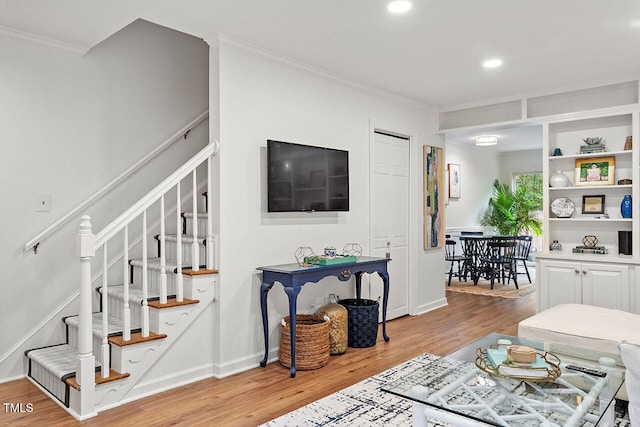 living room with light wood-type flooring and crown molding