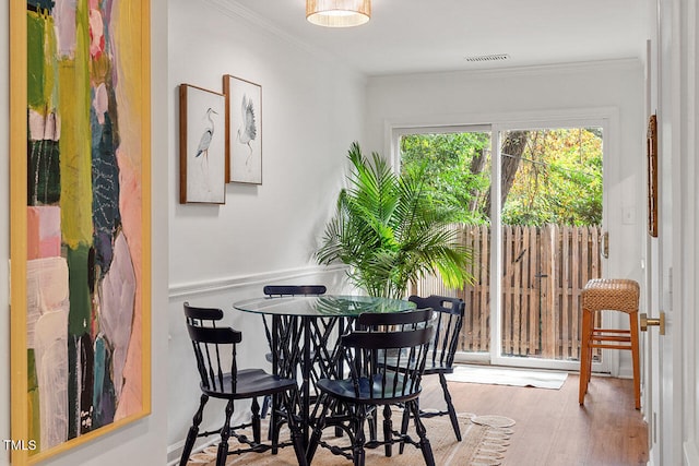 dining room featuring crown molding and light hardwood / wood-style flooring