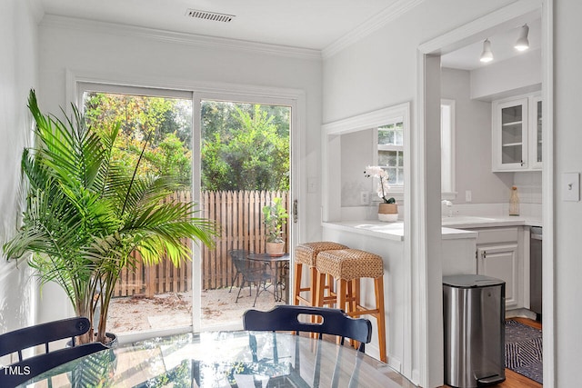 dining area featuring hardwood / wood-style flooring, sink, and crown molding