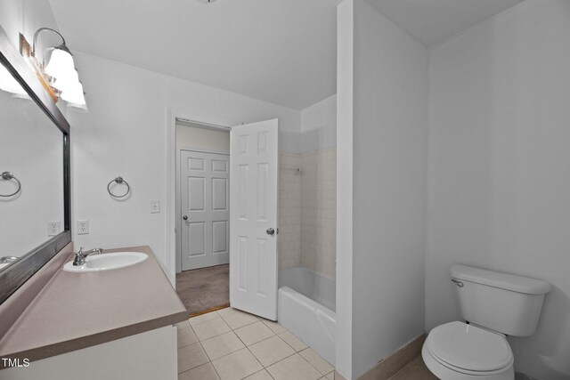 full bathroom with toilet, vanity, tiled shower / bath, and tile patterned floors