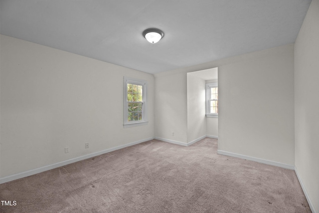 unfurnished room featuring light carpet and a healthy amount of sunlight