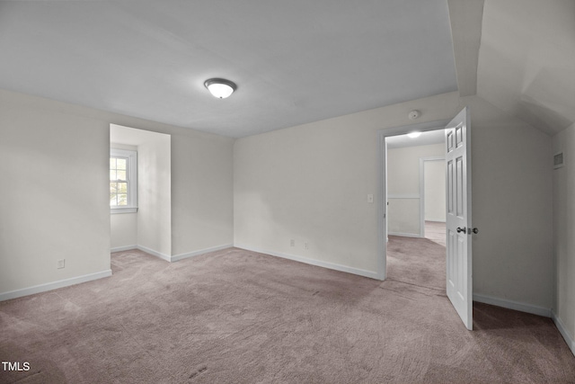 carpeted empty room with lofted ceiling