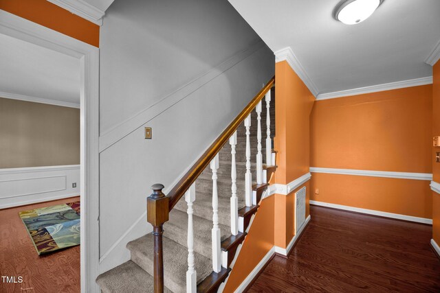 stairs featuring hardwood / wood-style flooring and ornamental molding