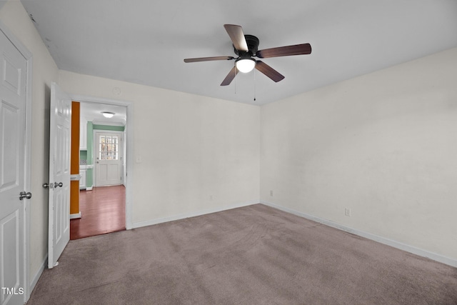 empty room featuring ceiling fan and carpet