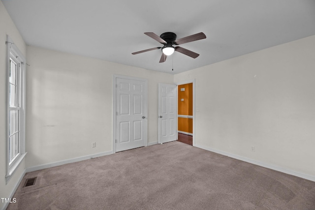 carpeted empty room featuring ceiling fan