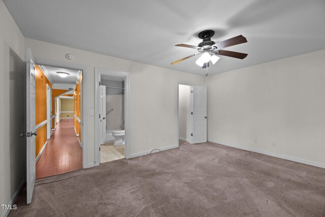 unfurnished bedroom featuring connected bathroom, light carpet, and ceiling fan