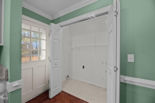 clothes washing area featuring tile patterned flooring, electric dryer hookup, and crown molding