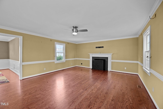 unfurnished living room with ornamental molding, ceiling fan, hardwood / wood-style floors, and a healthy amount of sunlight