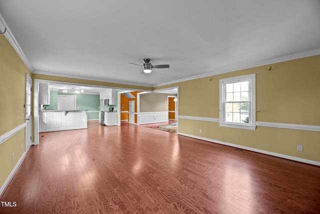 unfurnished living room featuring ceiling fan, wood-type flooring, and ornamental molding