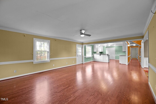 unfurnished living room with hardwood / wood-style floors, ceiling fan, and crown molding