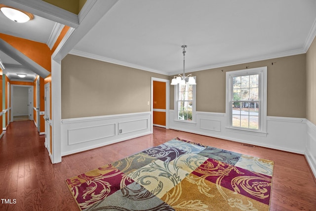 dining space with ornamental molding, hardwood / wood-style floors, and an inviting chandelier