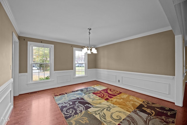 dining room featuring wood-type flooring, crown molding, and a notable chandelier