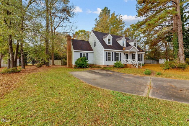 cape cod home featuring a front yard