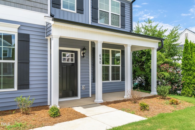 view of exterior entry featuring covered porch