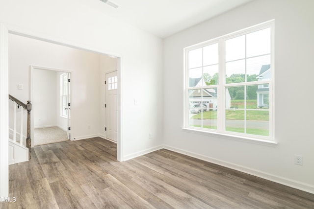 empty room featuring hardwood / wood-style flooring and a healthy amount of sunlight