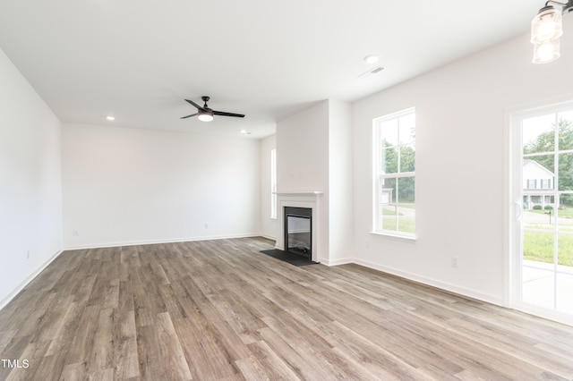 unfurnished living room with plenty of natural light, ceiling fan, and light hardwood / wood-style flooring