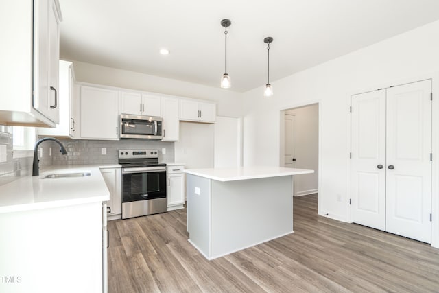 kitchen featuring white cabinets, sink, appliances with stainless steel finishes, and a center island