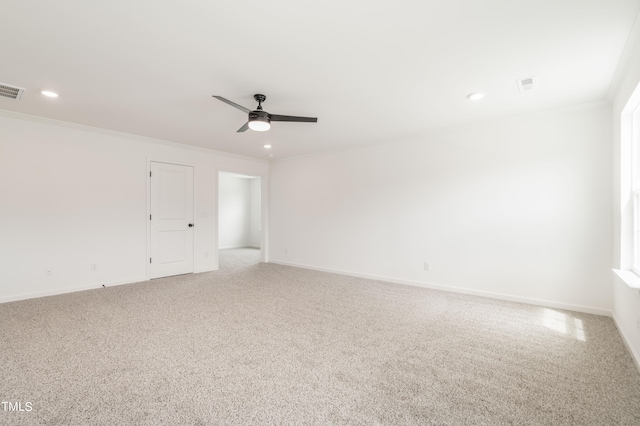 carpeted spare room featuring ceiling fan and crown molding