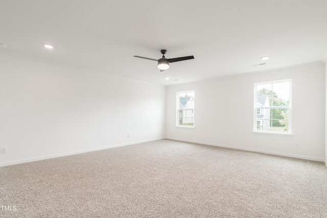 carpeted empty room with ornamental molding, ceiling fan, and plenty of natural light