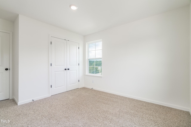 unfurnished bedroom featuring carpet flooring and a closet