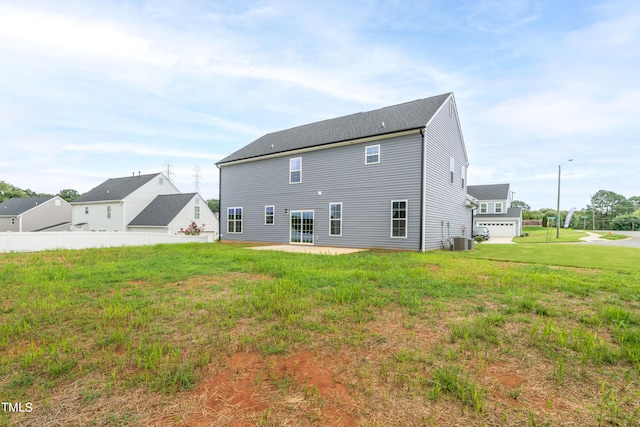 rear view of property featuring central AC, a yard, and a patio area