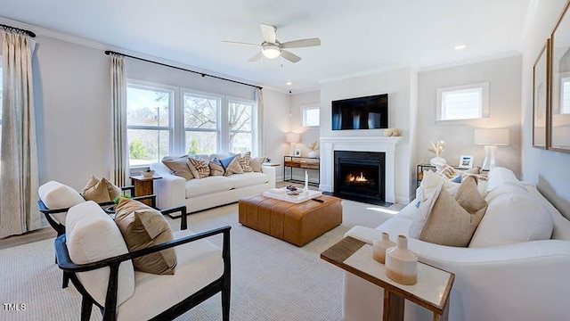 carpeted living room featuring a wealth of natural light, ceiling fan, and ornamental molding