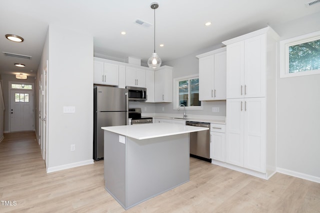 kitchen featuring a kitchen island, sink, a healthy amount of sunlight, and stainless steel appliances