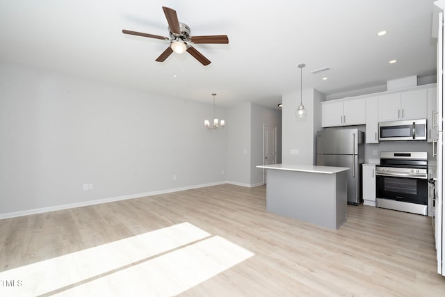 kitchen featuring stainless steel appliances, hanging light fixtures, light hardwood / wood-style floors, white cabinets, and a center island