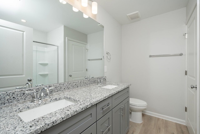 bathroom with toilet, a shower, vanity, and hardwood / wood-style flooring