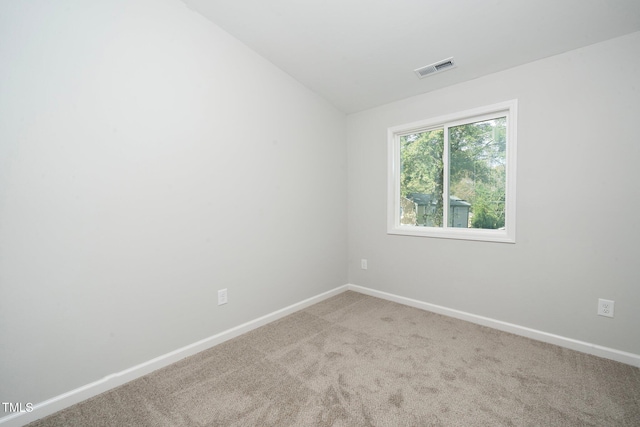 carpeted empty room with lofted ceiling