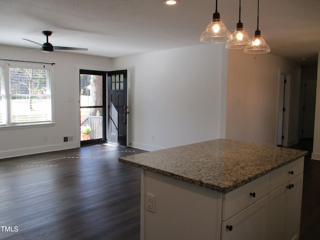 kitchen with white cabinetry, ceiling fan, decorative light fixtures, a kitchen island, and dark wood-type flooring