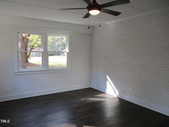 unfurnished room with dark hardwood / wood-style flooring, ceiling fan, and brick wall