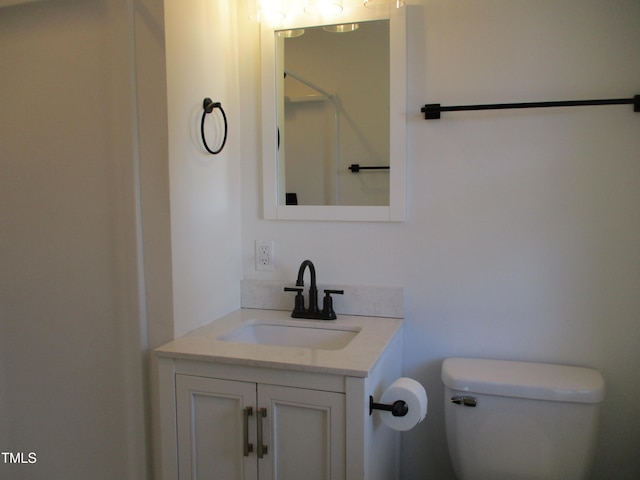 bathroom with walk in shower, vanity, and toilet