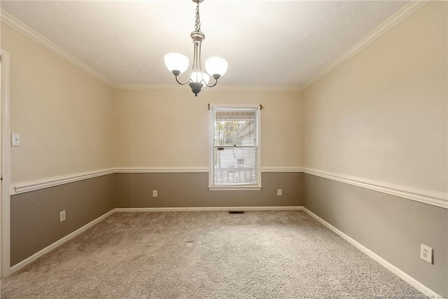 carpeted spare room with an inviting chandelier and ornamental molding