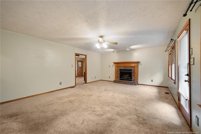 unfurnished living room with a textured ceiling, a brick fireplace, light carpet, and ceiling fan