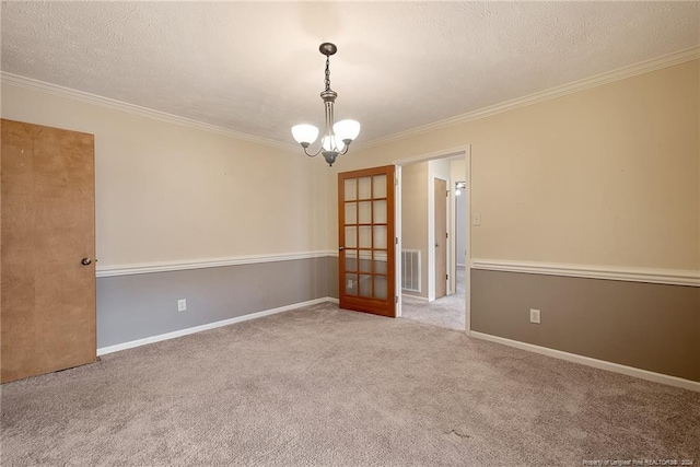 spare room featuring a textured ceiling, french doors, light carpet, and crown molding