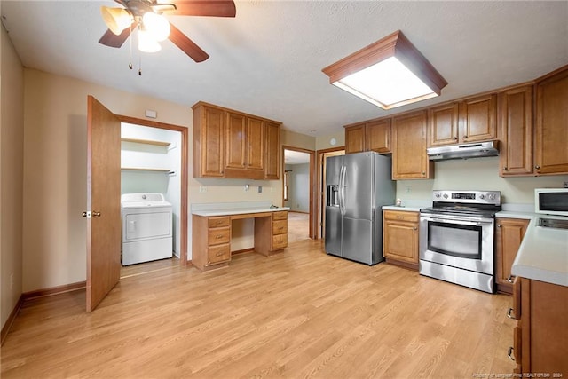 kitchen featuring stainless steel appliances, washer / dryer, ceiling fan, and light wood-type flooring