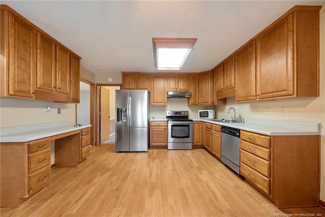 kitchen featuring a textured ceiling, light wood-type flooring, sink, and stainless steel appliances