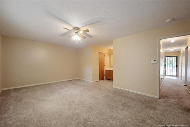 carpeted empty room with ceiling fan and a textured ceiling