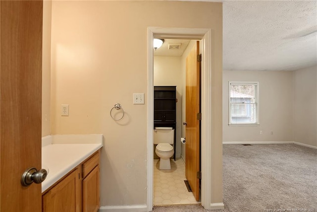 bathroom featuring vanity, toilet, and a textured ceiling