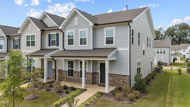 view of front of house with central AC and a front lawn