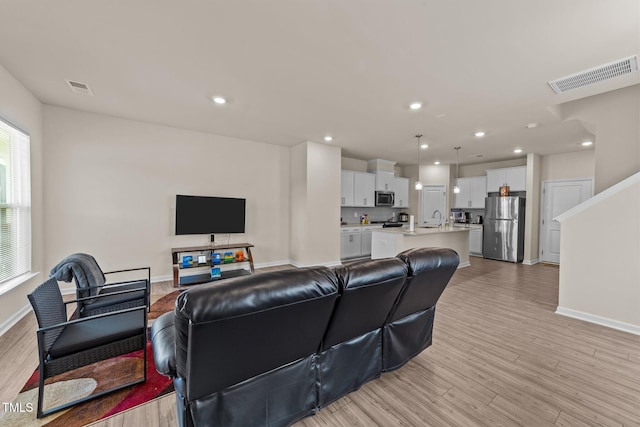 living room featuring light hardwood / wood-style floors and sink