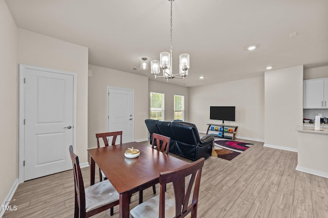 dining area featuring light hardwood / wood-style floors and a chandelier