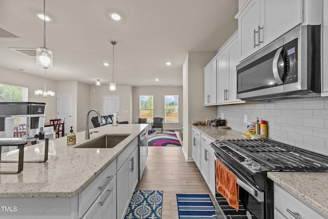 kitchen with light hardwood / wood-style flooring, appliances with stainless steel finishes, sink, and plenty of natural light